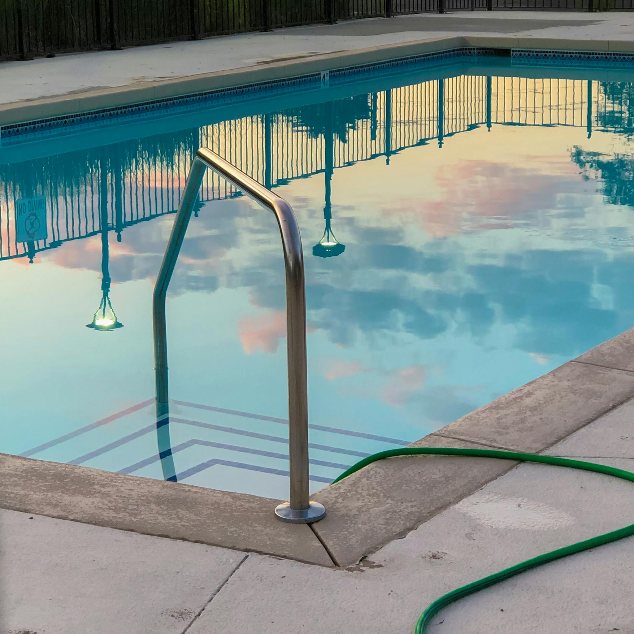 Outdoors swimming pool reflecting clear blue sky